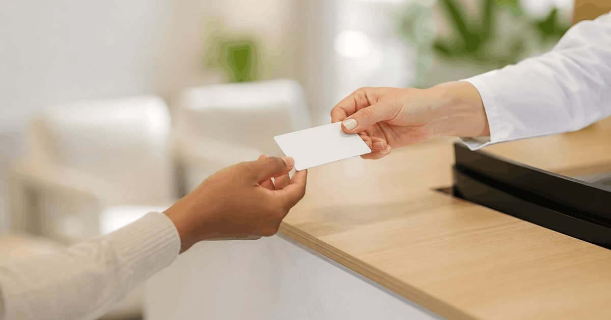 Patient presenting a health insurance card at a UAE clinic reception desk